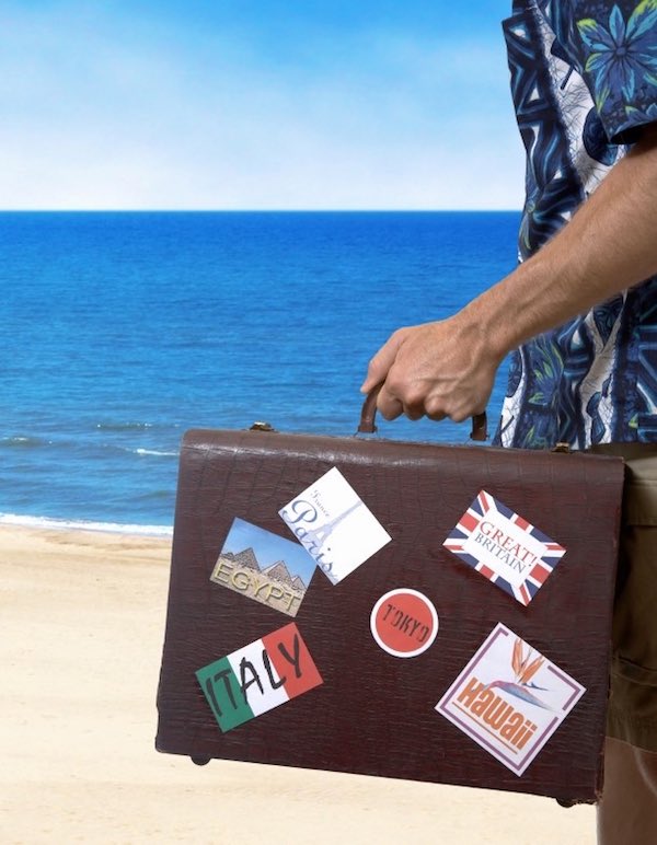Man in Hawaiian shirt, holding a suitcase with travel stickers (stickers are my own, cheesy designs).  Clipping path included
