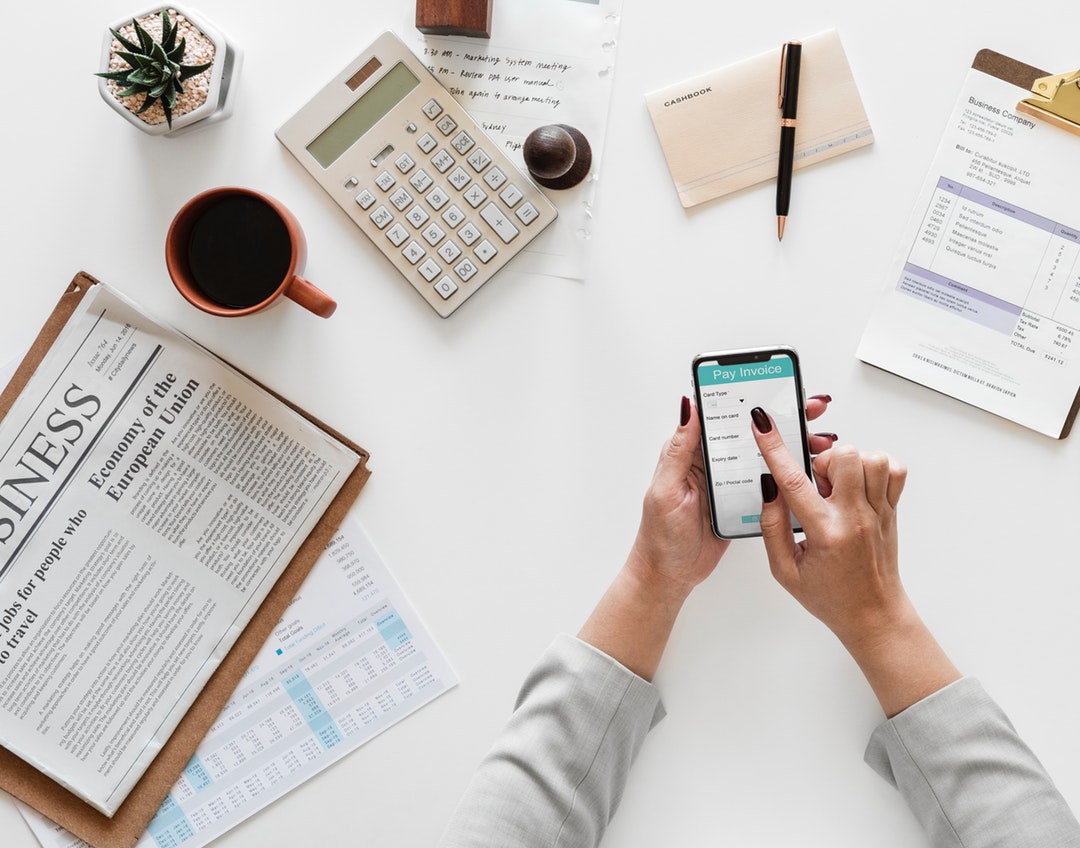 person paying invoices on a phone