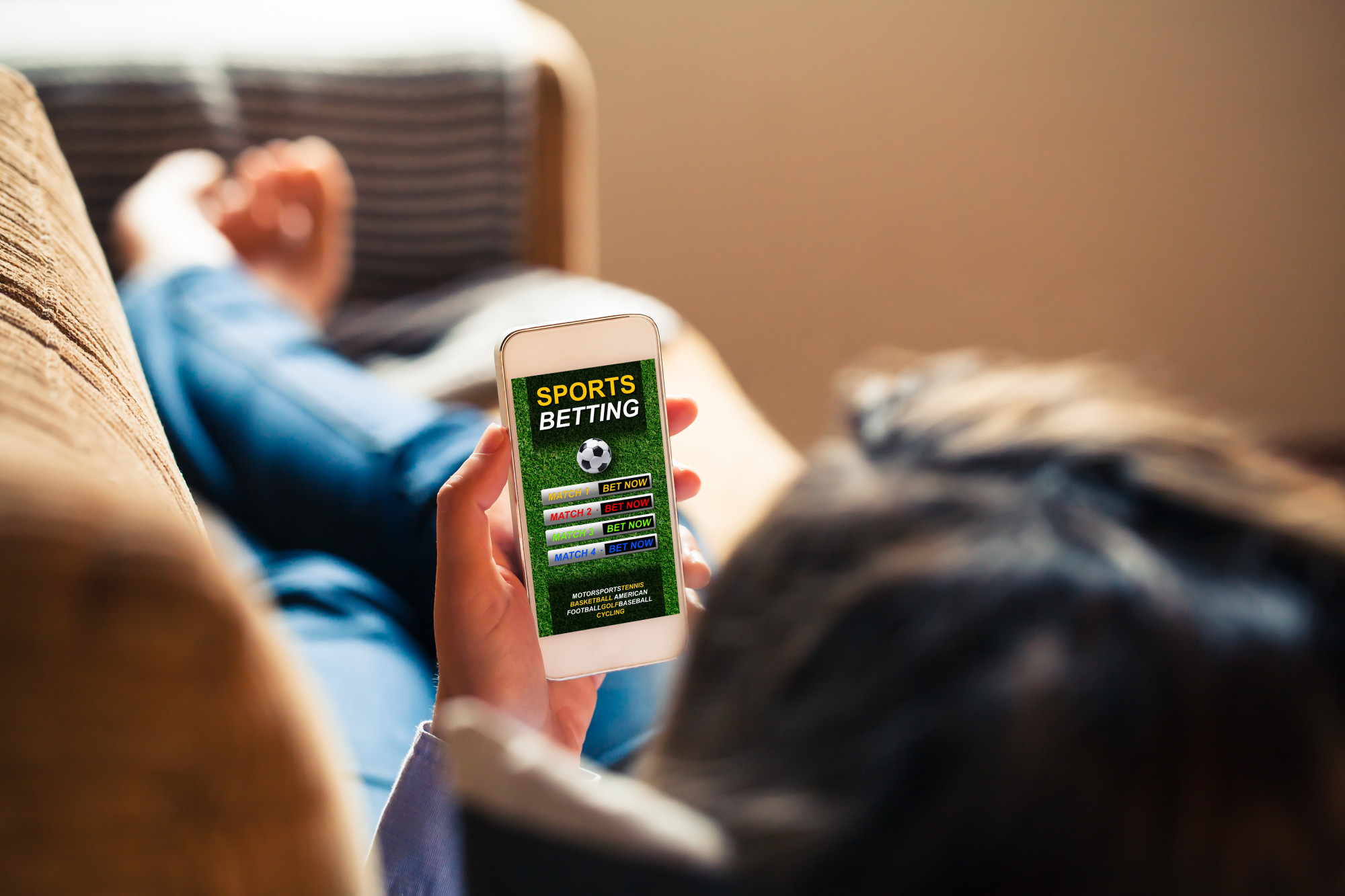 person with sports betting app on mobile phone