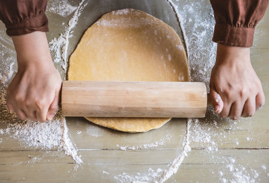 person rolling out baking dough