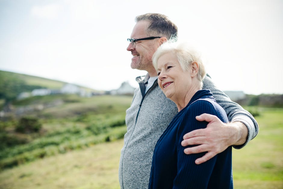 elderly man with arm around woman