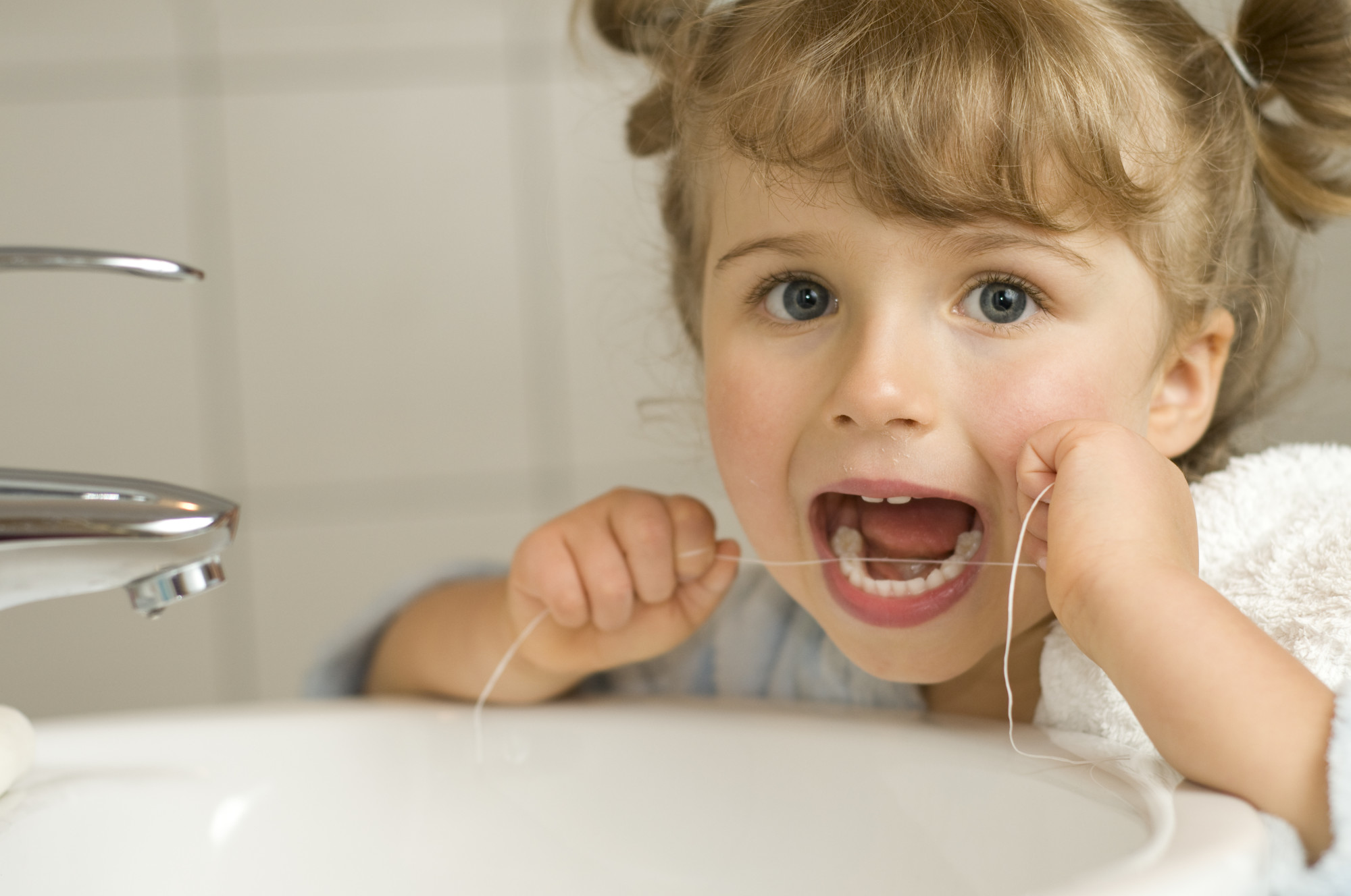 Child Flossing Her Teeth